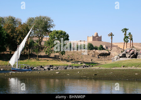 Felucca sailing past the Mausoleum of Aga Khan in Aswan, Egypt Stock Photo
