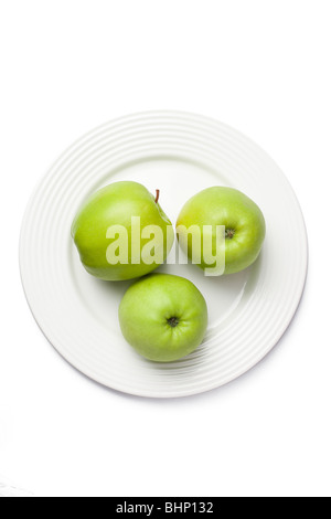 three green apples on white plate Stock Photo