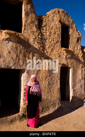 Berber woman in front of her old ancient Berber village in Ksar in Metameur near Djerba Tunisia Africa Stock Photo