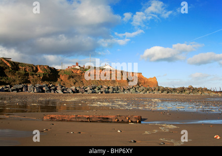 Old groyne post and rock armour protecting eroding cliffs on Happisburgh Beach, Norfolk, United Kingdom. Stock Photo
