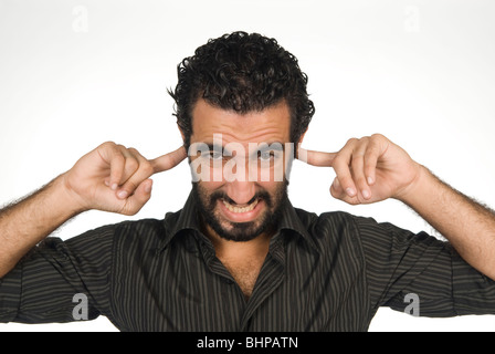 25 years old Middle Eastern man fingers over ears Stock Photo
