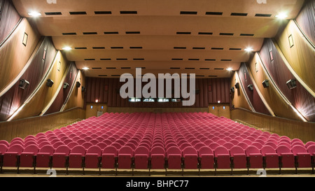 Empty cinema auditorium with line of pink chairs.. Stock Photo