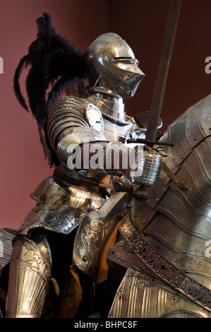 Feathered helmet and horse armor. Classic Medieval Full Suit of Armor. Stock Photo