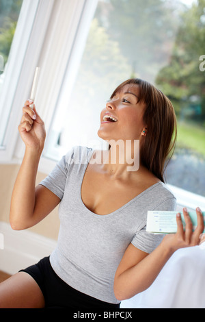 Woman happy with results of pregnancy test Stock Photo