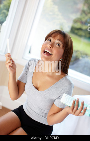Woman happy with results of pregnancy test Stock Photo