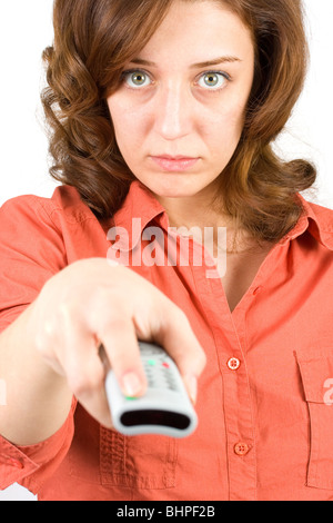 Portrait of a young woman using tv remote control isolated on white background Stock Photo