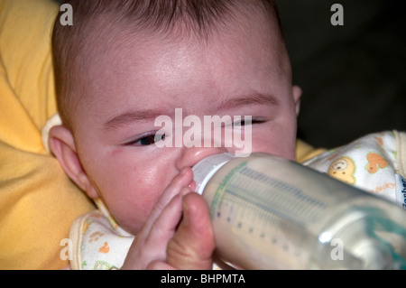 2 year old baby girl drinks mild formula from a baby bottle Stock Photo -  Alamy