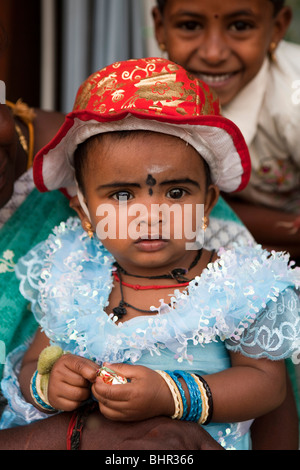 India, Kerala, Munnar, young female child dressed in frilly blue dress and red sun hat Stock Photo