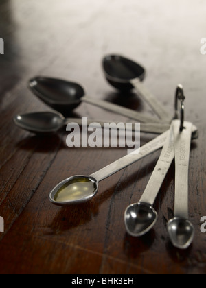 measuring spoons on a table top oil olive Stock Photo