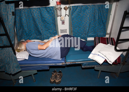 India, train travel, female tourist sleeping in second class two tier ...