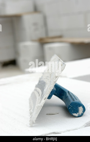 Mason's trowel placed on white hollow bricks Stock Photo