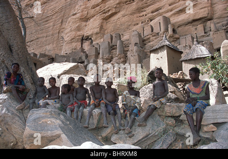 A group of children sitting in the shade on some rocks in the village of Yaye, Pays Dogon, Mali. Stock Photo