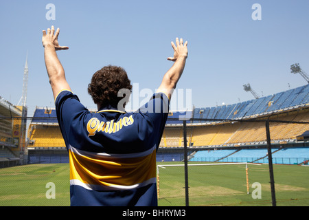 male boca juniors fan holds arms aloft in the interior of Alberto J Armando la bombonera stadium home to atletico boca juniors Stock Photo