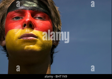 a patriotic and serious looking German football supporter with the German's flag painted on his face Stock Photo