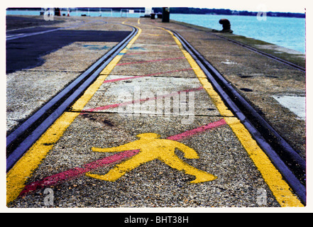 A no walking/crossing sign painted in yellow paint Stock Photo