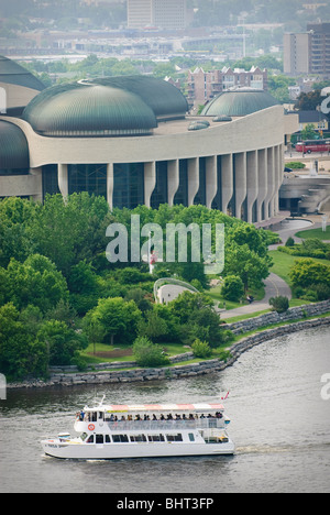 A tour boat on the Ottawa River passes in front of the Canadian Museum of Civilization in Hull, Quebec, Canada. Stock Photo
