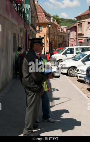 Policeman issuing parking violation ticket in Sighisoara Romania Eastern Europe Stock Photo