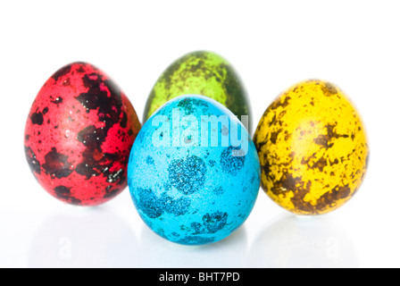 Four quail eggs colored for Easter isolated on white Stock Photo