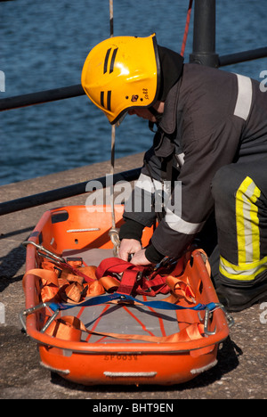 Fireman preparing basket stretcher for rescue Stock Photo