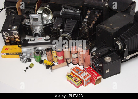 Vintage film of many different formats  and makes (Kodak, Agfa and others) along with cameras it was found in (Brownie, Agfa, folding and box-type). Stock Photo