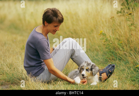 woman with Australian Shepherd dog puppy Stock Photo