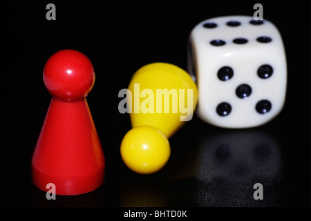 Two game pieces and a dice. Stock Photo