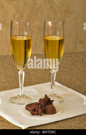 Two glasses of white wine and hand made chocolates Stock Photo