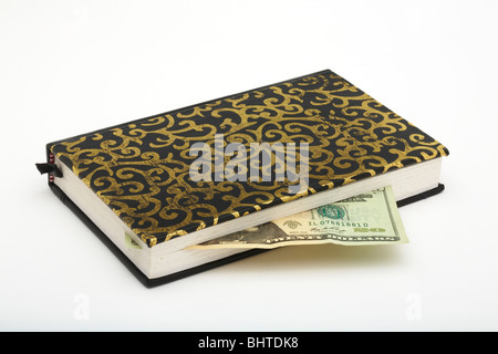 Hand Made leather gold leaf print book on white background with 20 US Dollar note as marker Stock Photo