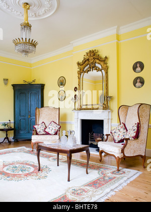 Antique mirror above cream fireplace in cream country living room with ...