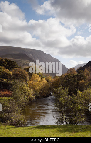 View along Afon Ogwen River in Nant Ffrancon valley towards Snowdonia mountains in autumn. Bethesda, Gwynedd, North Wales, UK. Stock Photo