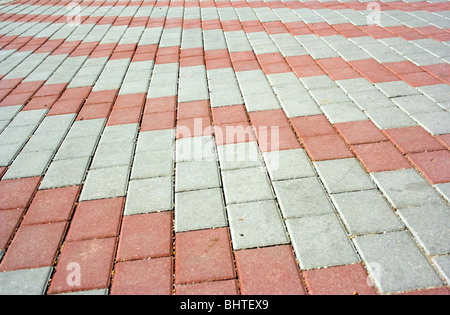 Pavement with a pattern from red and gray rows of concrete blocks Stock Photo