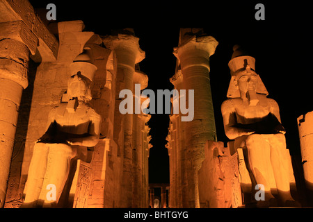 Floodlit Ramesses II colossi and Amenhotep's colonnade at Luxor Temple in Luxor, Egypt Stock Photo