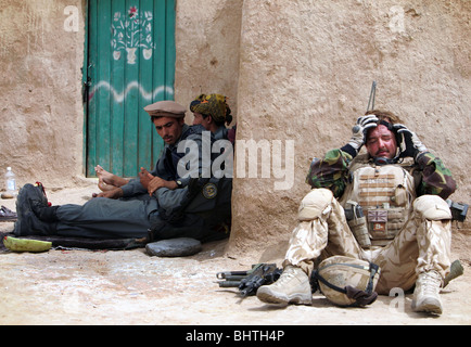 A soldier takes a break from the heat during a British military offensive in the town of Gorup-E-Shesh Kalay  in Afghanistan. Stock Photo