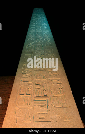 The illuminated red granite obelisk of Ramesses the Great at the main entrance of Luxor Temple (a UNESCO World Heritage Site) in Luxor, Egypt Stock Photo