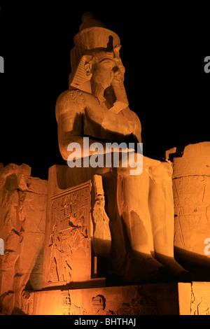 Sitting Ramesses II colossus inside Luxor Temple at night in Luxor, Egypt Stock Photo