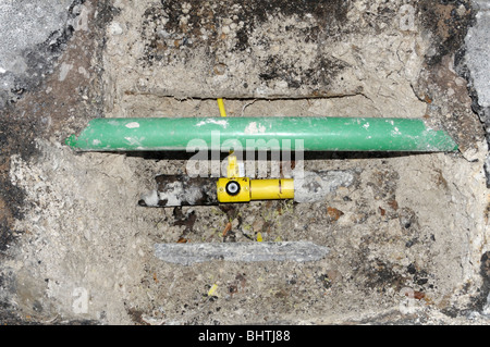 New yellow plastic domestic gas pipe connected to the new main pipe. The green pipe is for fiber optics. Stock Photo