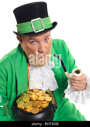 Leprechaun in bright green clothes holding a smoking pipe and pot full of gold Stock Photo