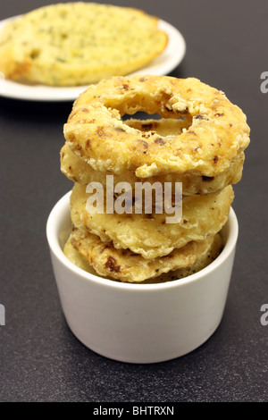 A side order of onion rings displayed in a small white ramekin dish Stock Photo