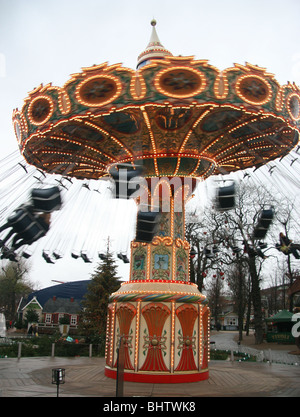 A carousel in Tivoli Gardens brightens the day on an otherwise rainy, dark and dreary November day in Copenhagen, Denmark Stock Photo