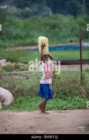 Girl carrying water on head in Uganda, Africa Stock Photo