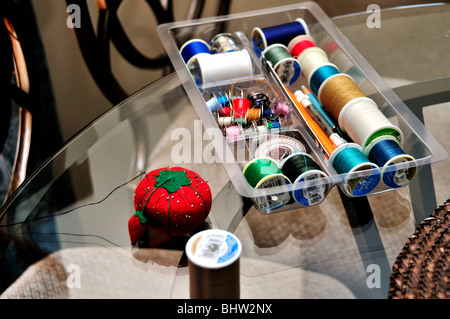 A sewing tray filled with spools of thread and other sewing items.