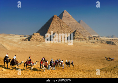 Tourists riding camels at the Pyramids of Giza, Cairo, Egypt. Stock Photo
