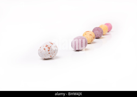 Candy covered small chocolate easter eggs from low viewpoint against white background. Stock Photo
