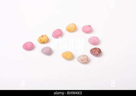 Candy covered small chocolate easter eggs from low viewpoint against white background.