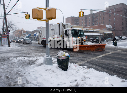 A snow plow clears snow from a street in New York City Stock Photo