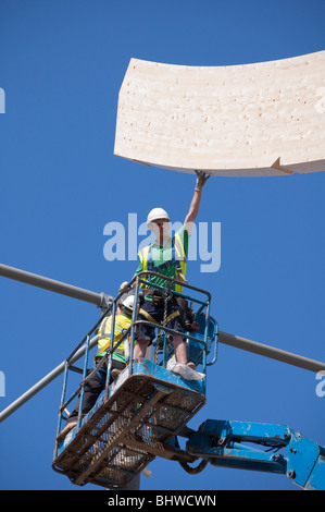 High level Construction workers building laminated wood wave roof on Mountbatten centre in Portsmouth Stock Photo