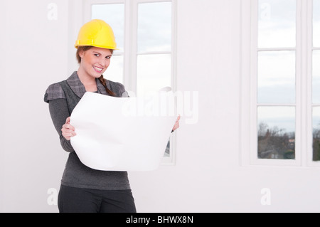 Young architect in a white room is reading a plan Stock Photo