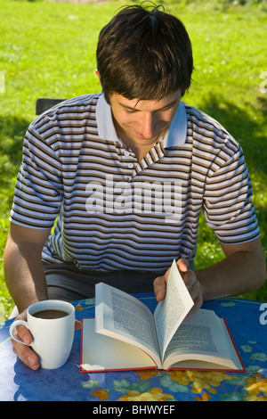 Young man reading a book in the garden Stock Photo