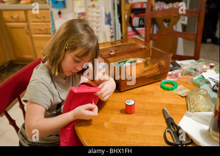 7 year old girl learning to sew Stock Photo