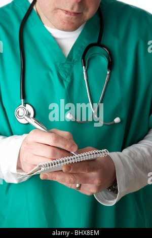 man wearing medical scrubs and stethoscope writing notes in a notebook Stock Photo